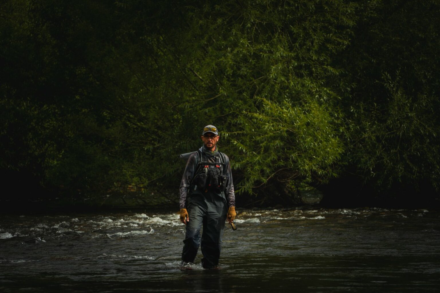Fully equipped fly fisherman, rod in hand, on a Patagonian river